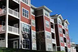 An apartment building with balconies and a grassy area.